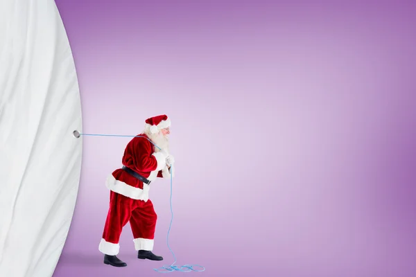 Santa claus pulling a rope — Stock Photo, Image