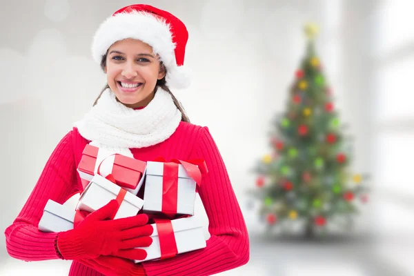 Imagen compuesta de morena festiva sosteniendo regalos — Foto de Stock