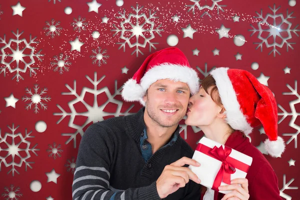 Imagen compuesta de pareja sosteniendo un regalo de Navidad —  Fotos de Stock