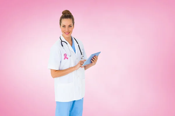 Composite image of pretty nurse using tablet pc — Stock Photo, Image