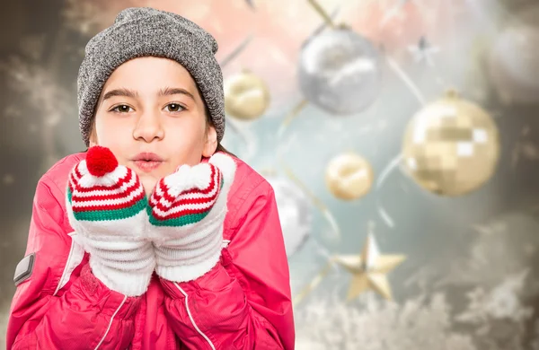 Wrapped up little girl blowing over hands — Stock Photo, Image