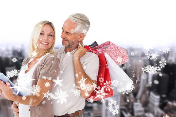 Casal feliz com sacos de compras e tablet pc — Fotografia de Stock