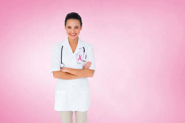 Sammansatt bild av söt sjuksköterska med armarna korsade — Stockfoto