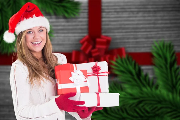 Imagen compuesta de rubia festiva sosteniendo un montón de regalos —  Fotos de Stock