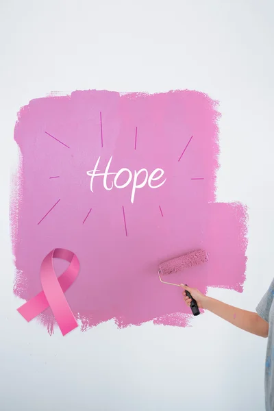 Composite image of woman painting her wall pink — Stock Photo, Image