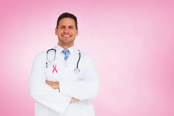 Composite image of handsome doctor with arms crossed — Stock Photo, Image