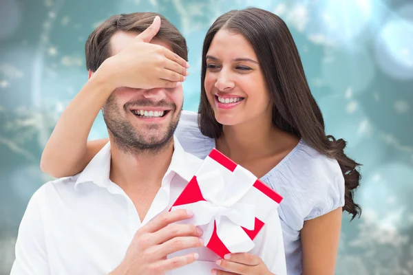 Woman surprising boyfriend with gift — Stock Photo, Image