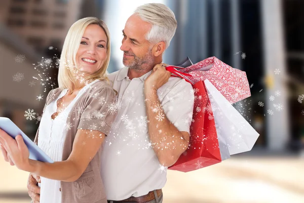 幸せなカップルの買い物袋とタブレット pc — ストック写真