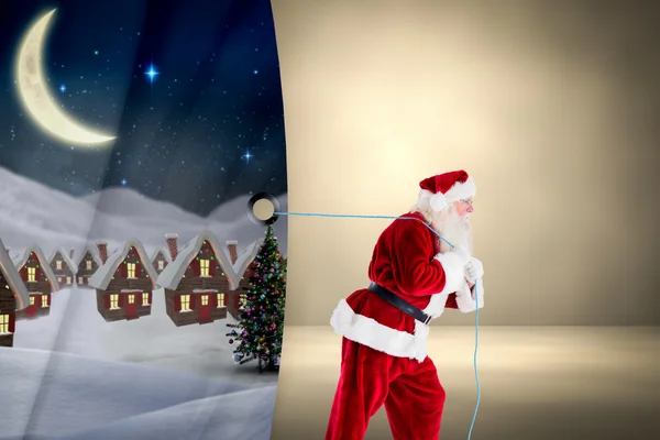 Composite image of santa claus pulling rope — Stock Photo, Image