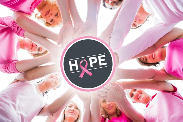 Divers vrouwen glimlachend in cirkel dragen van roze — Stockfoto