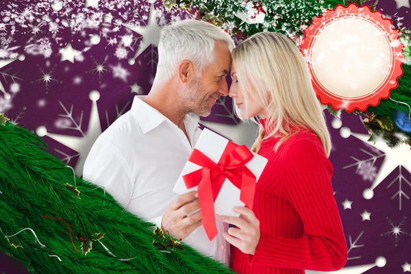 Zusammengesetztes Bild eines liebenden Paares mit Geschenk — Stockfoto