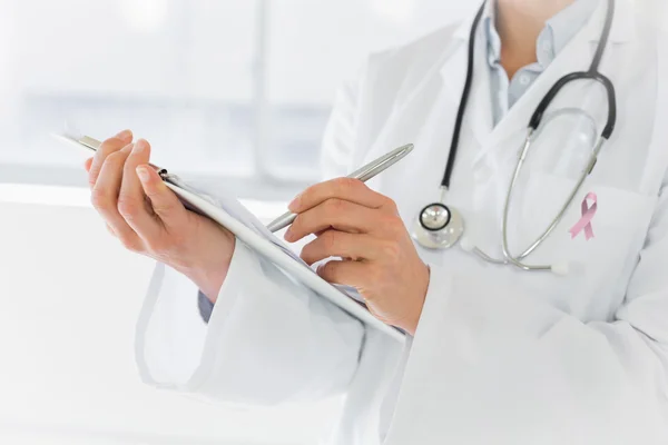 Mid section of a female doctor writing report — Stock Photo, Image