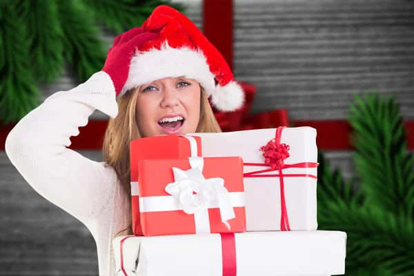 Image composite de blonde festive tenant pile de cadeaux — Photo