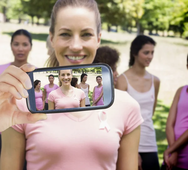 Imagem composta de mão segurando smartphone mostrando — Fotografia de Stock