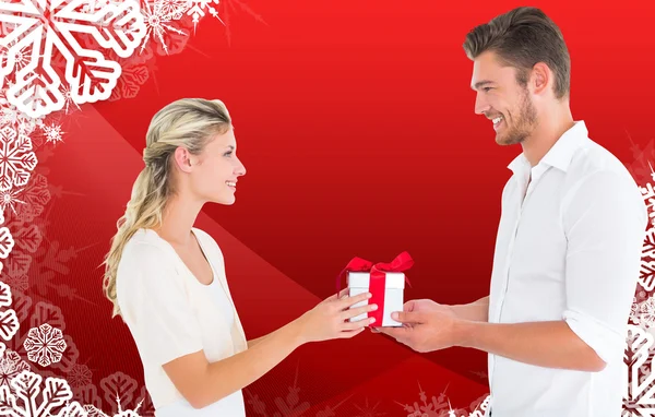 Složený obraz mladého páru s dárkem — Stock fotografie