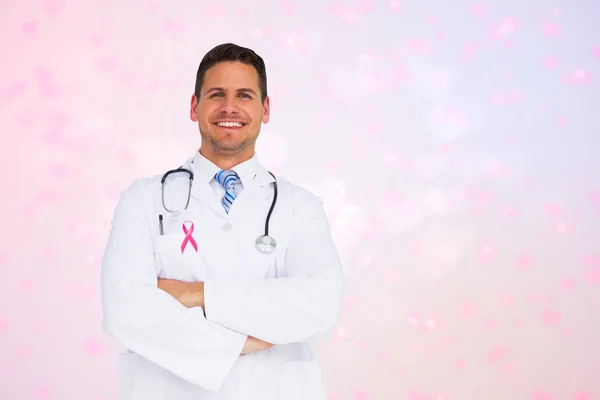 Composite image of handsome doctor with arms crossed — Stock Photo, Image