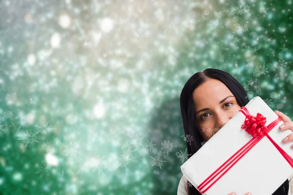 Composite image of woman holding a large present — Stock Photo, Image