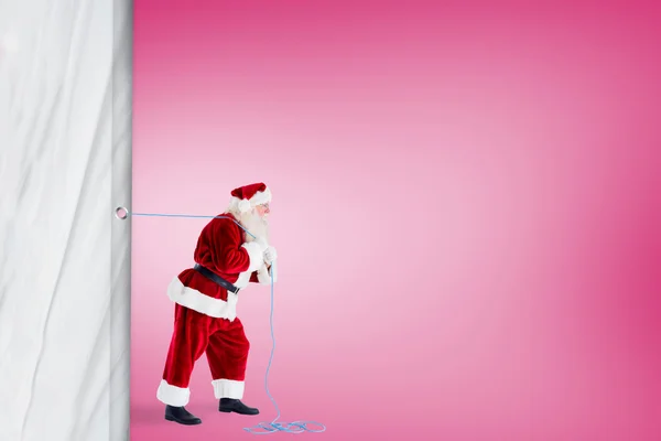 Santa claus pulling a rope — Stock Photo, Image