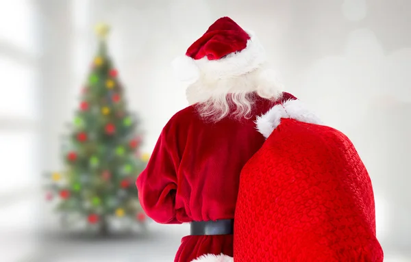 Zusammengesetztes Bild des Weihnachtsmannes mit Sack und Pack — Stockfoto