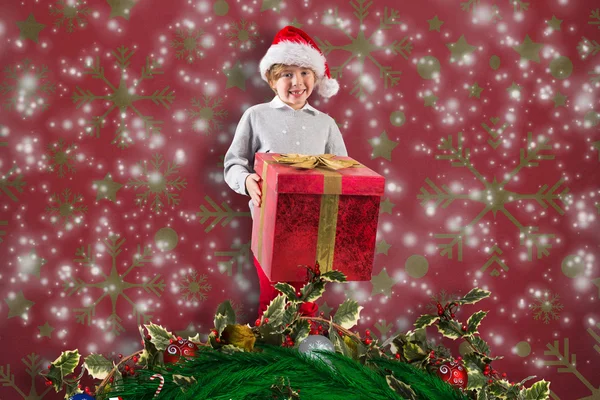 Imagen compuesta de niño festivo sosteniendo regalo — Foto de Stock