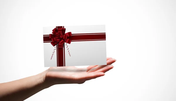 Composite image of female hand presenting a card — Stock Photo, Image