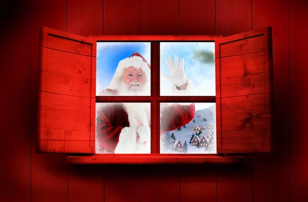 Weihnachtsmann überbringt Geschenke gegen Fenster — Stockfoto