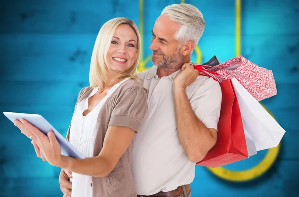 Pareja feliz con bolsas de compras y tableta pc — Foto de Stock