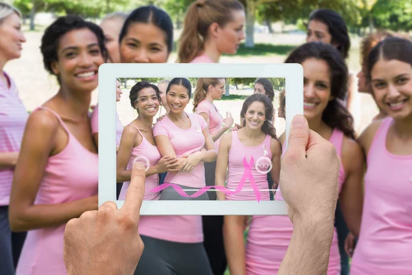 Imagen compuesta de la mano que sostiene la tableta pc — Foto de Stock