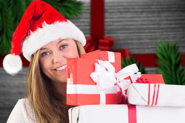 Imagen compuesta de rubia festiva sosteniendo un montón de regalos —  Fotos de Stock