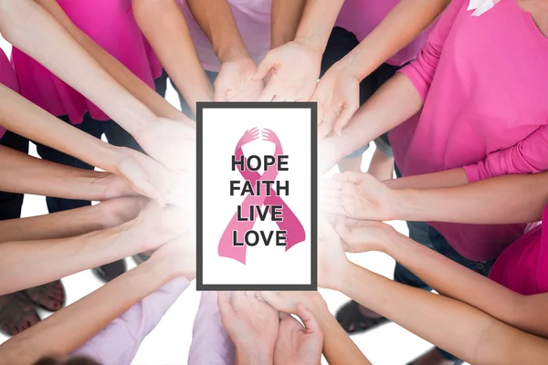 Composite image of hands joined in circle holding breast cancer — Stock Photo, Image