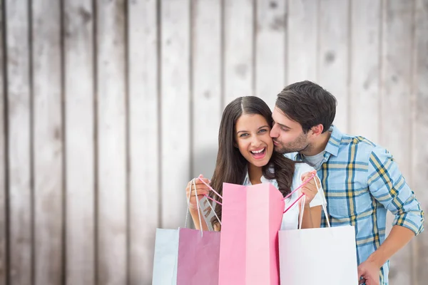 Zusammengesetztes Bild eines glücklichen Paares mit Einkaufstüten — Stockfoto