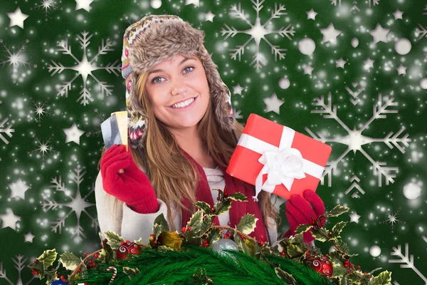 Zusammengesetztes Bild einer glücklichen Blondine in Winterkleidung mit Geschenken — Stockfoto