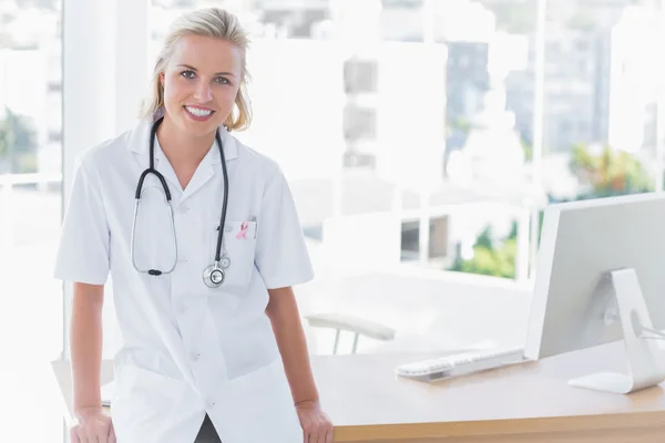 Sammansatt bild av attraktiva sjuksköterska lutar på skrivbord — Stockfoto