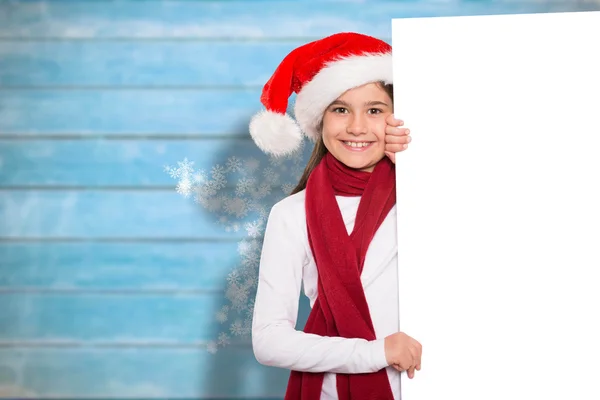 Composite image of festive little girl showing card — Stock Photo, Image