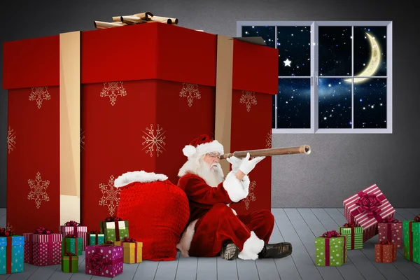 Zusammengesetzte Aufnahme des Weihnachtsmannes, der durch ein Teleskop blickt — Stockfoto