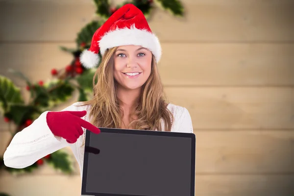 Composite image of festive blonde pointing to laptop — Stock Photo, Image