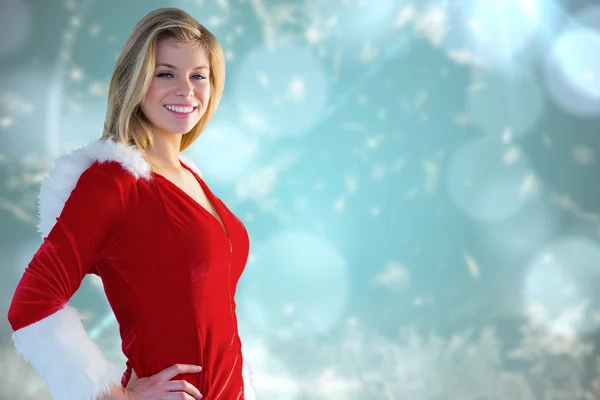 Composite image of pretty girl smiling in santa outfit — Stock Photo, Image