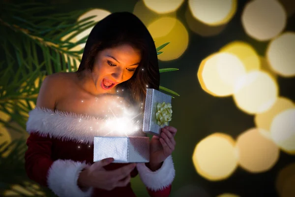 Composite image of sexy santa girl opening gift — Stock Photo, Image