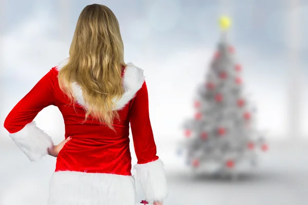 Samengesteld beeld van mooi meisje in santa outfit holding cadeau — Stockfoto