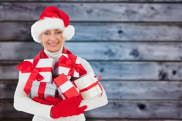 Image composite de femme festive tenant des cadeaux — Photo