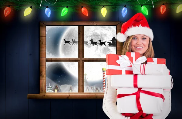 Sammansatt bild av festliga blond anläggning högen av gåvor — Stockfoto