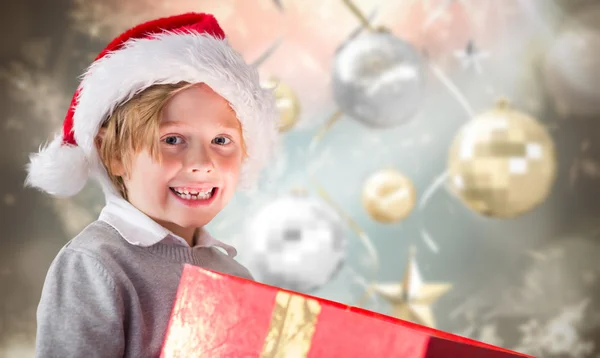 Composite image of festive boy opening gift — Stock Photo, Image