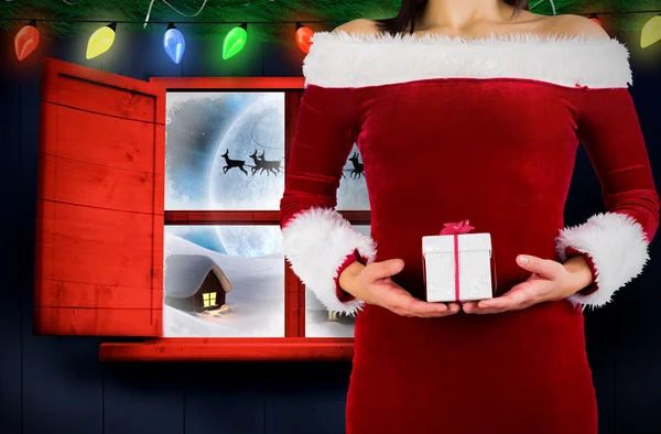 Pretty girl in santa outfit holding gift — Stock Photo, Image