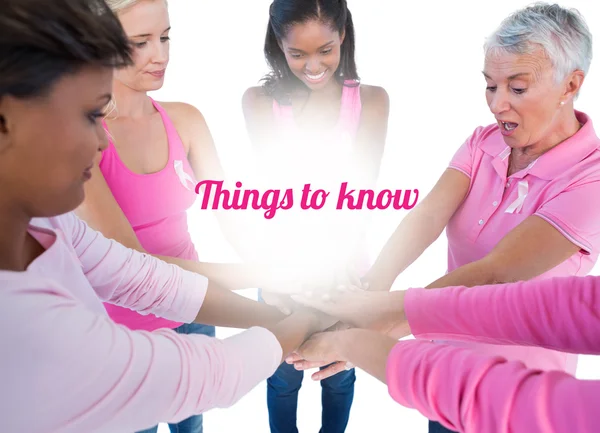 Women wearing pink and ribbons for breast cancer putting hands t — Stock Photo, Image