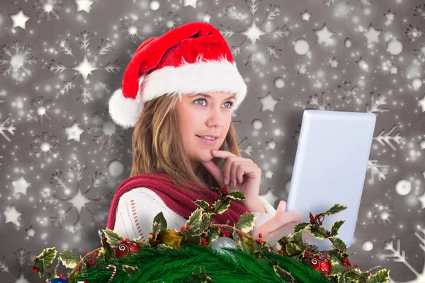 Composite image of festive blonde looking at tablet pc — Stock Photo, Image