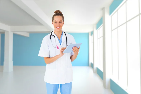 Composite image of pretty nurse using tablet pc — Stock Photo, Image