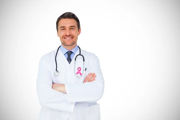 Immagine composita di bel giovane medico con le braccia incrociate — Foto Stock