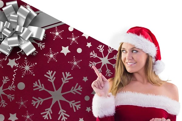 Composite image of festive blonde smiling and pointing — Stock Photo, Image