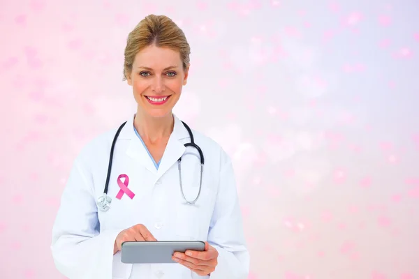Composite image of blonde doctor using tablet pc — Stock Photo, Image
