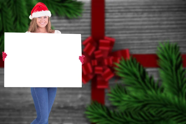 Composite image of festive blonde holding a poster — Stock Photo, Image